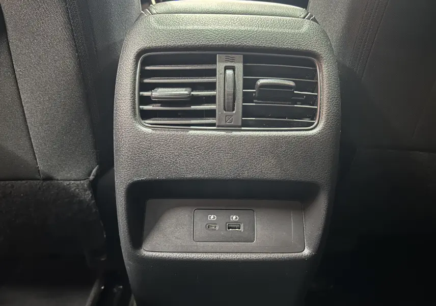 Détail de la console arrière noire du Nissan Qashqai 1.3 Hybrid 140 N-Connecta avec prises USB et aérateurs.