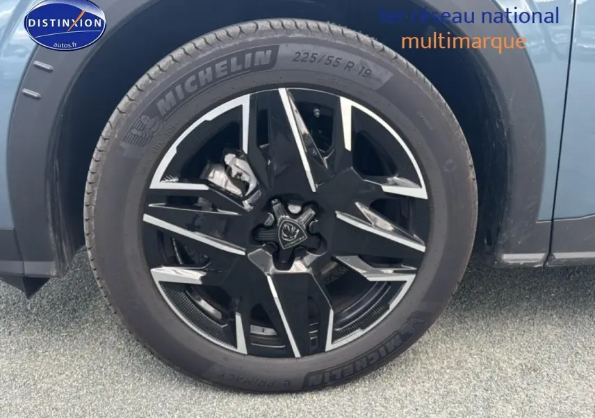 Gros plan sur la roue avant gauche du Peugeot 3008 bleu 2025 avec jante alu noire et détails argentés.