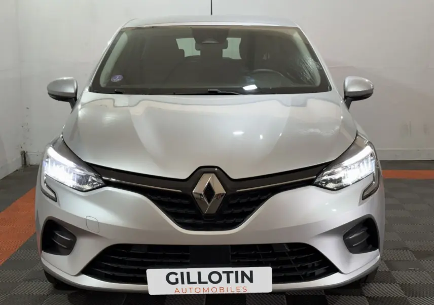 Vue frontale d'une Renault Clio Business E-Tech hybride 2021 gris clair avec phares LED allumés et calandre noire.