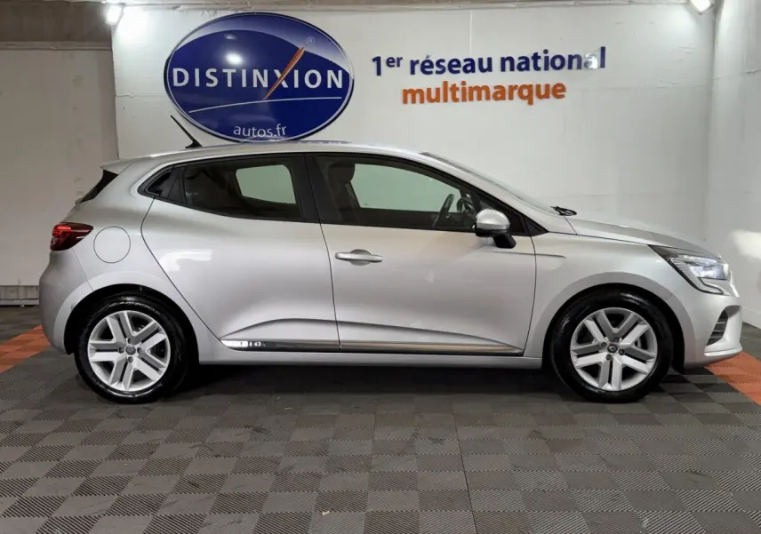 Profil droit d'une Renault Clio Business E-Tech hybride gris clair 2021, avec jantes alliage et feux LED visibles.