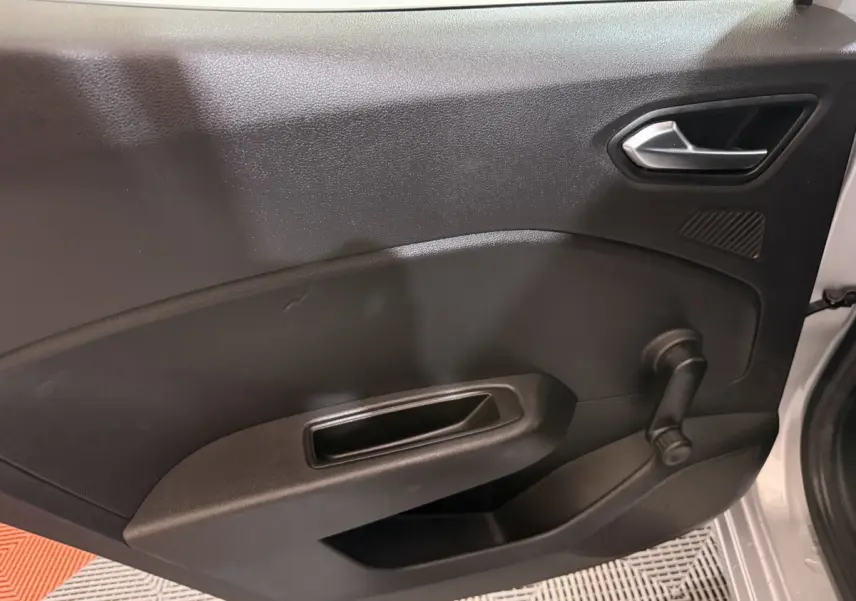 Vue intérieure de la porte avant droite d’une Renault Clio Business E-Tech hybride gris clair avec poignée et manivelle de vitre.