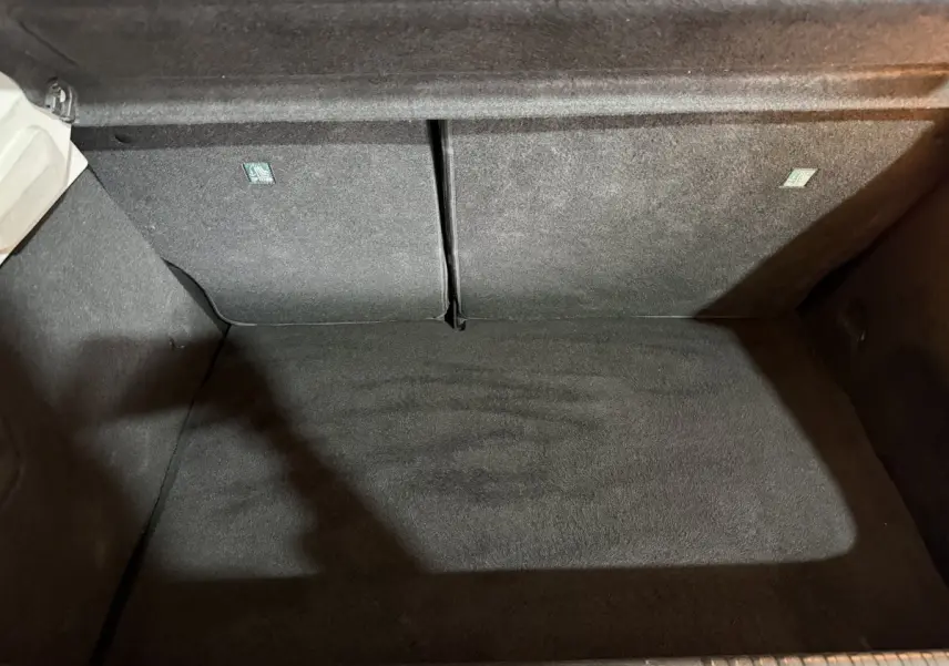 Coffre ouvert de Renault Clio Business E-Tech hybride 2021, vue plongeante sur le tapis de coffre gris foncé.