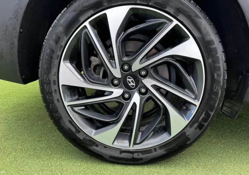 Gros plan sur la jante alliage 17'' bicolore du Hyundai Tucson III rouge métallisé, avec pneu Ecospot.