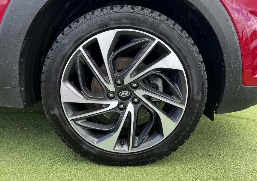 Gros plan sur la jante alliage 17'' bicolore du Hyundai Tucson rouge métallisé, avec flanc de pneu visible.