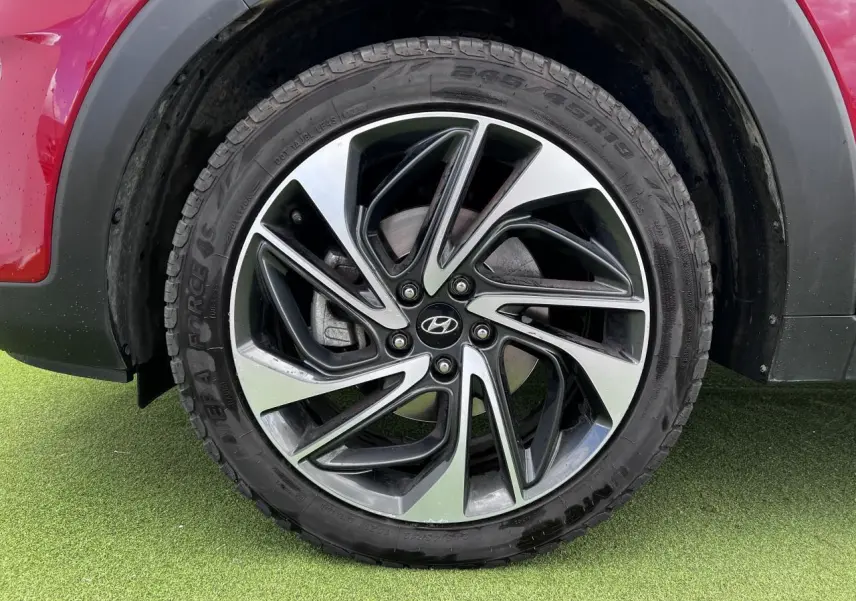 Gros plan sur la jante alliage 17'' bicolore du Hyundai Tucson III rouge métallisé, côté arrière droit.