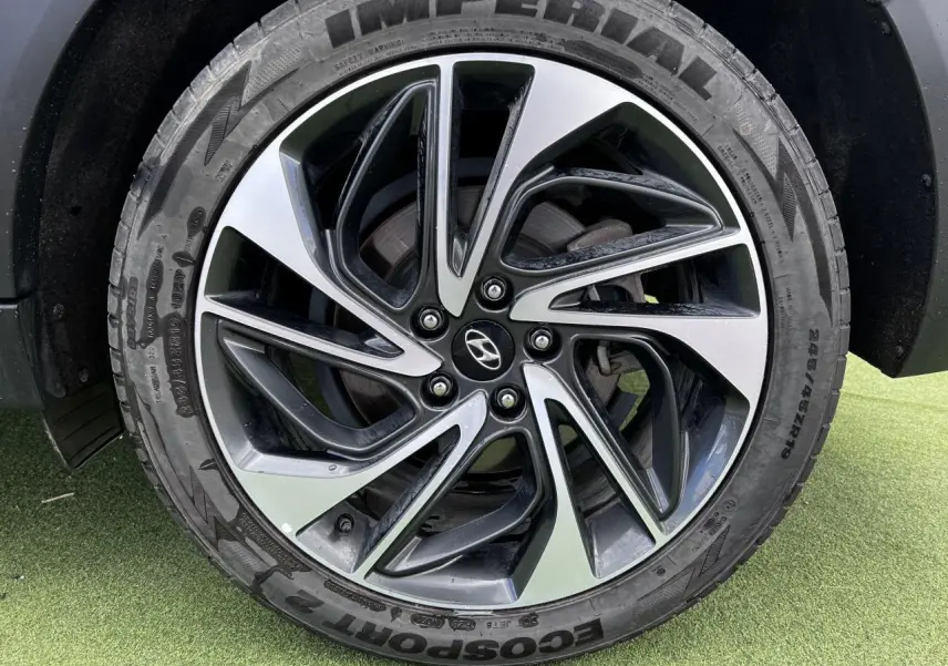 Gros plan sur la jante alliage 17'' bicolore et le pneu Imperial du Hyundai Tucson rouge métallisé côté droit.