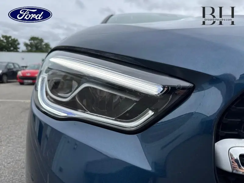 Gros plan sur le phare avant gauche d'un Mercedes GLA 250 e bleu denim métallisé, soulignant ses LED distinctives.