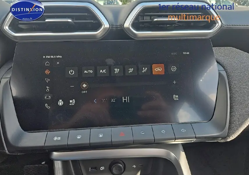 Écran tactile central du tableau de bord du MG ZS Hybrid noir, avec commandes climatisation visibles.