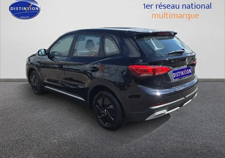 Vue 3/4 arrière droite du SUV noir MG ZS Hybrid 197 avec jantes noires et feux arrière LED allumés.