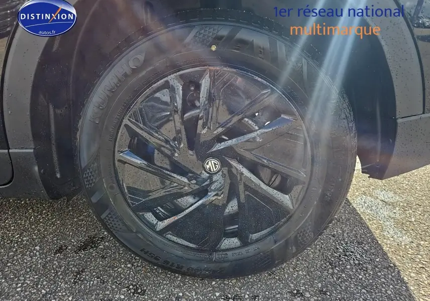 Gros plan sur la roue avant droite noire du MG ZS Hybrid 197 avec jante acier et enjoliveur noir brillant.
