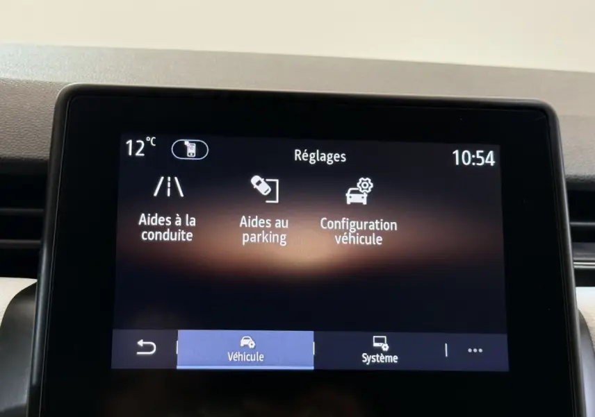 Écran tactile central de la Renault Clio blanc 2023 affichant les réglages d’aides à la conduite et au parking.