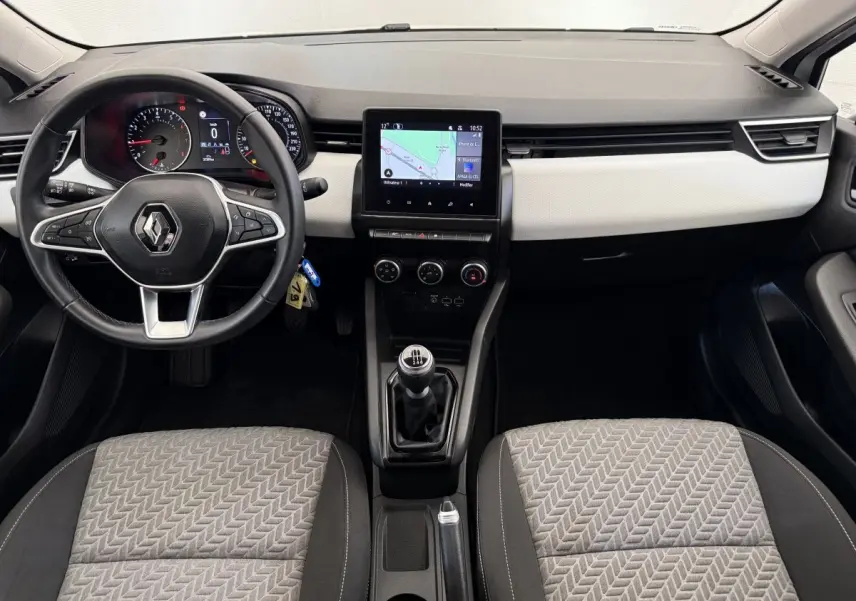 Vue intérieure avant de la Renault Clio Evolution TCe 100 GPL 2023, tableau de bord noir et beige avec écran tactile central.