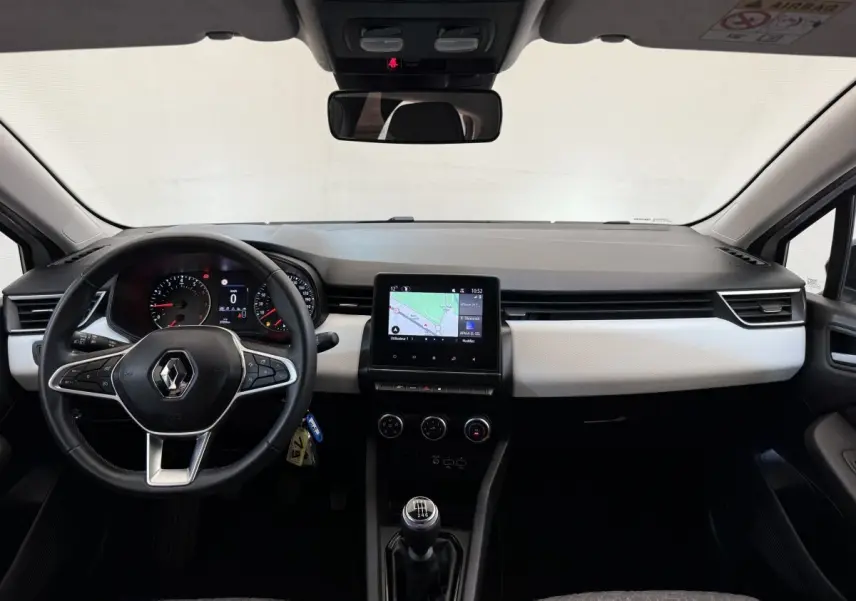 Vue intérieure avant de la Renault Clio Evolution TCe 100 GPL 2023, tableau de bord noir et blanc avec écran tactile central et volant cuir noir.