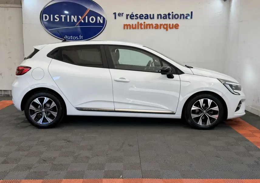 Profil droit d'une Renault Clio blanche 2023 Evolution TCe 100 GPL, avec jantes alliage et rétroviseurs noirs.