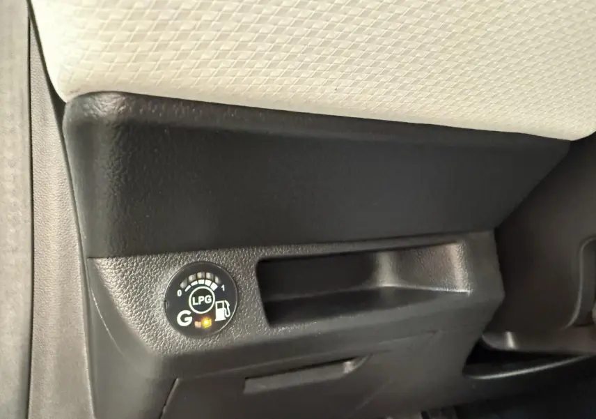 Gros plan sur le tableau de bord noir et beige de la Renault Clio blanc, avec indicateur de niveau GPL allumé.