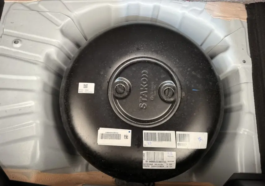 Gros plan sur le réservoir GPL noir installé dans le coffre d'une Renault Clio blanche Evolution TCe 100 GPL.