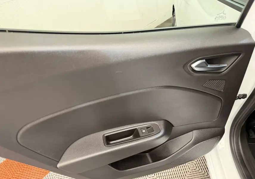 Vue intérieure de la porte arrière droite noire d’une Renault Clio blanche Evolution TCe 100 GPL 2023.