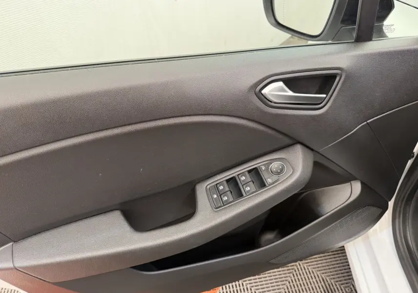 Vue intérieure sur la porte avant gauche de la Renault Clio blanche, avec commandes électriques des vitres et rétroviseurs.