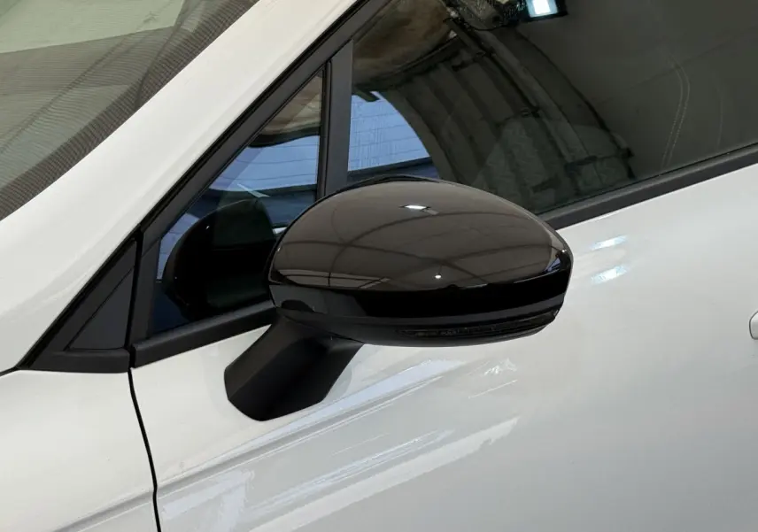 Rétroviseur noir brillant côté gauche sur porte blanche d’une Renault Clio Evolution TCe 100 GPL 2023.