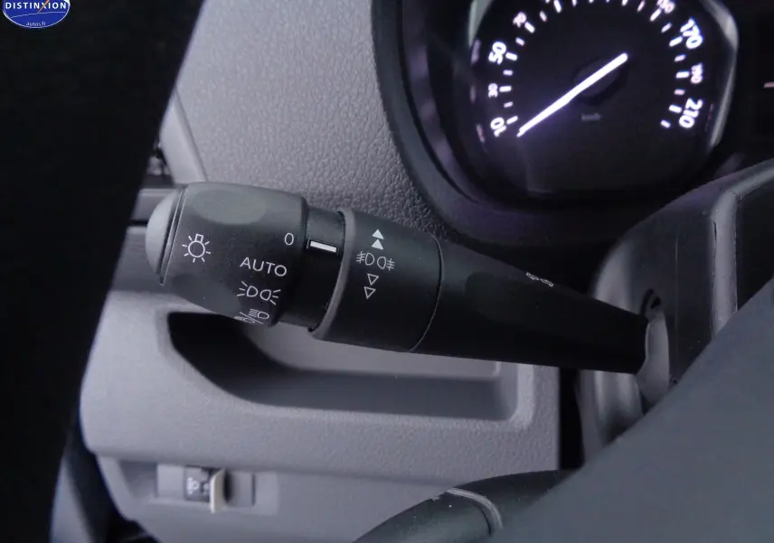 Gros plan sur la commande des phares du Peugeot Expert Fourgon gris, avec le compteur de vitesse en arrière-plan.