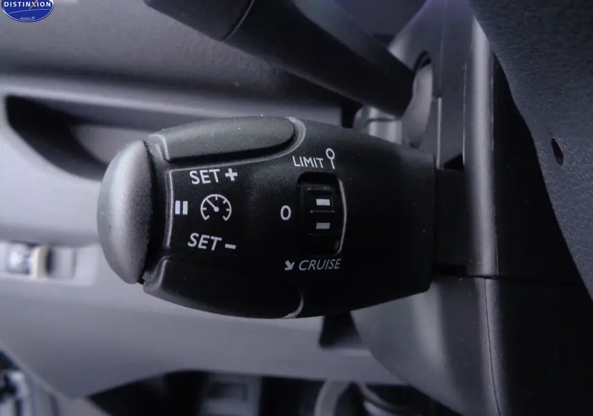 Gros plan sur la commande de régulateur de vitesse du Peugeot Expert Fourgon gris, avec boutons SET+, SET- et limiteur.