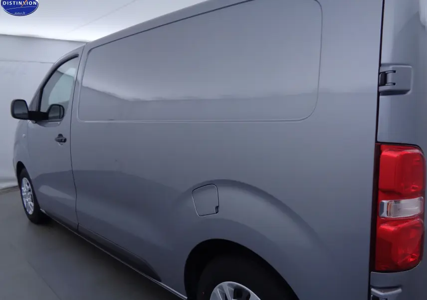 Vue 3/4 arrière côté droit d'un Peugeot Expert Fourgon gris Artense métallisé avec porte latérale fermée et feux arrière visibles.