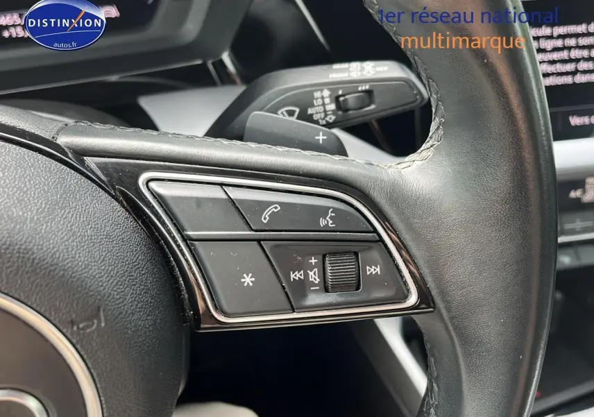 Gros plan sur les commandes du volant cuir multifonction de l'Audi A3 Sportback 2023, finition design.