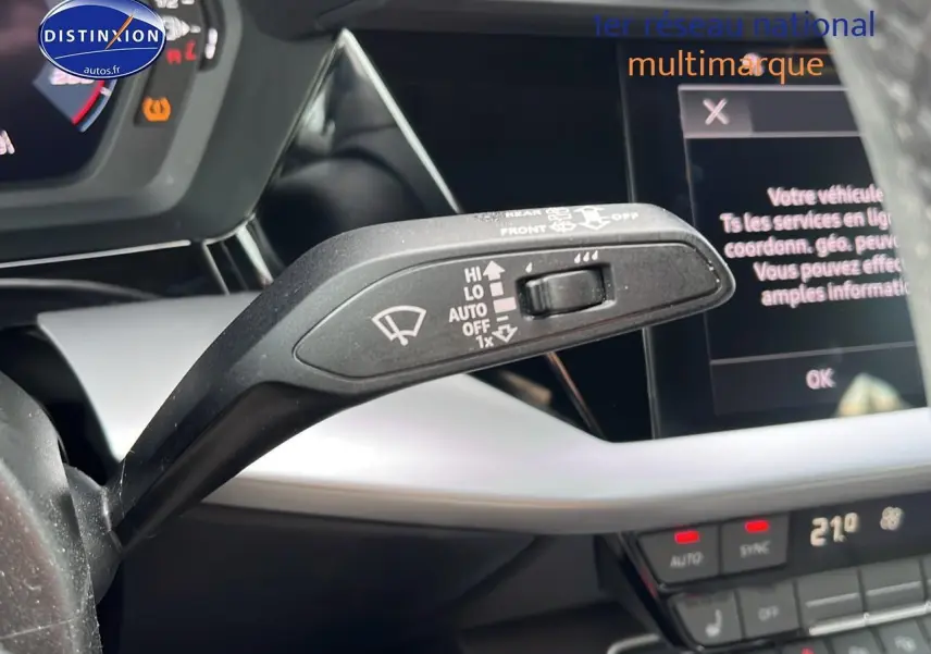 Le levier de commande des essuie-glaces en gros plan dans l'habitacle gris et noir de l'Audi A3 Sportback 2023.