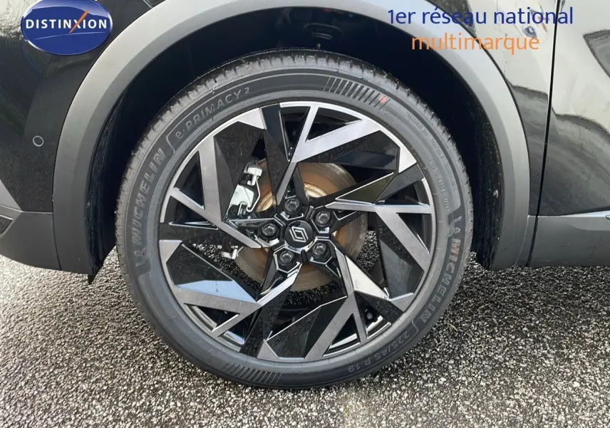 Gros plan sur la roue avant droite du Renault Captur E-Tech hybride noir étoile avec jante alu bicolore 19 pouces.