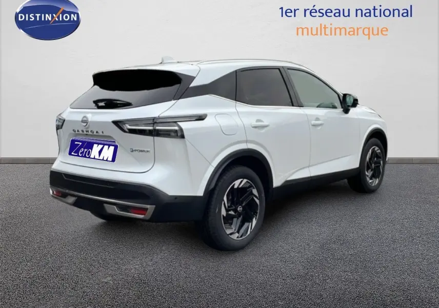 Vue 3/4 arrière droite du Nissan Qashqai blanc nacré métal 2025 avec jantes noires et toit contrasté.