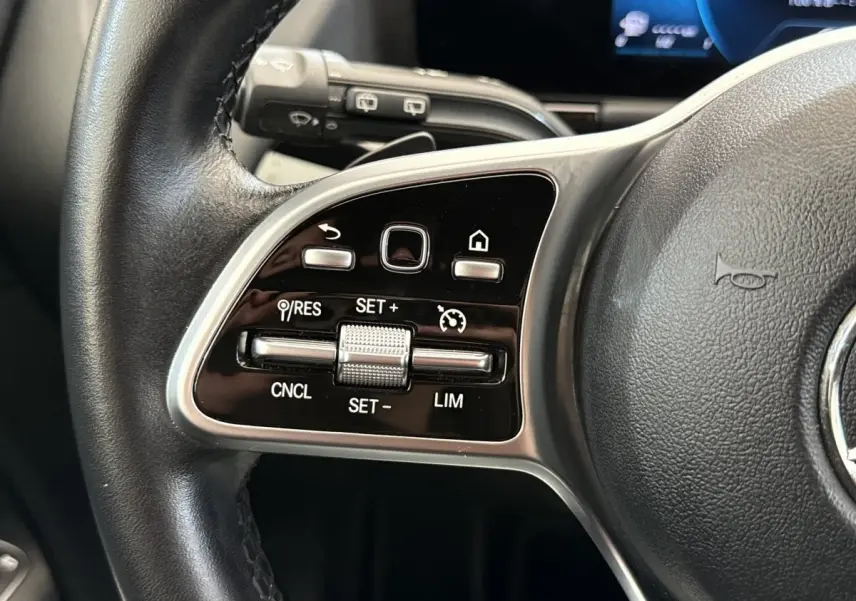 Gros plan sur les commandes du volant cuir noir d’une Mercedes GLA 250 e Business Line 2021.