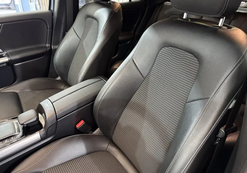 Gros plan sur les sièges avant noirs en cuir et tissu du Mercedes GLA 250 e Business Line, vue côté droit.
