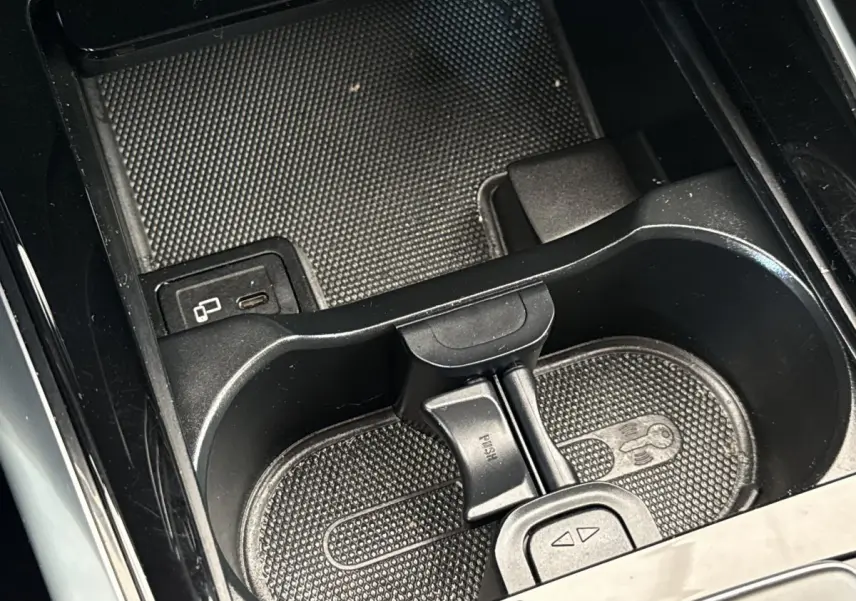 Gros plan sur le porte-gobelets noir et la console centrale du Mercedes GLA 250 e bleu, intérieur moderne et épuré.