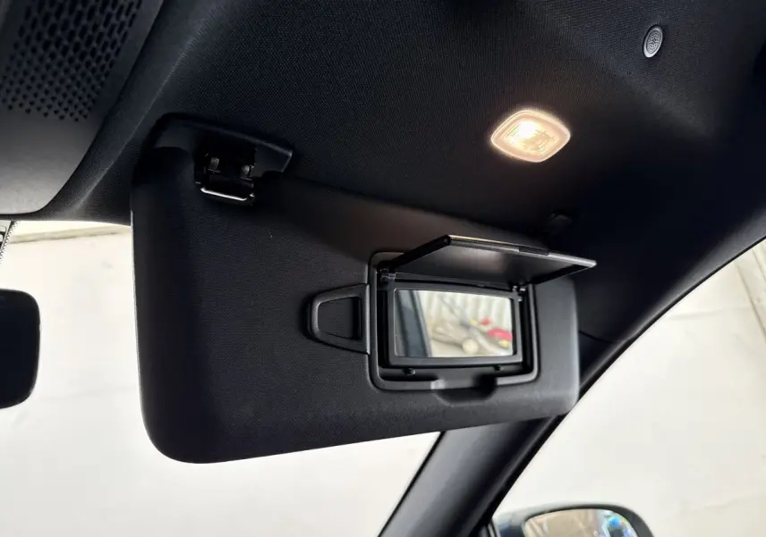 Miroir de courtoisie ouvert sur pare-soleil côté conducteur dans l'habitacle d'un Mercedes GLA bleu 2021.