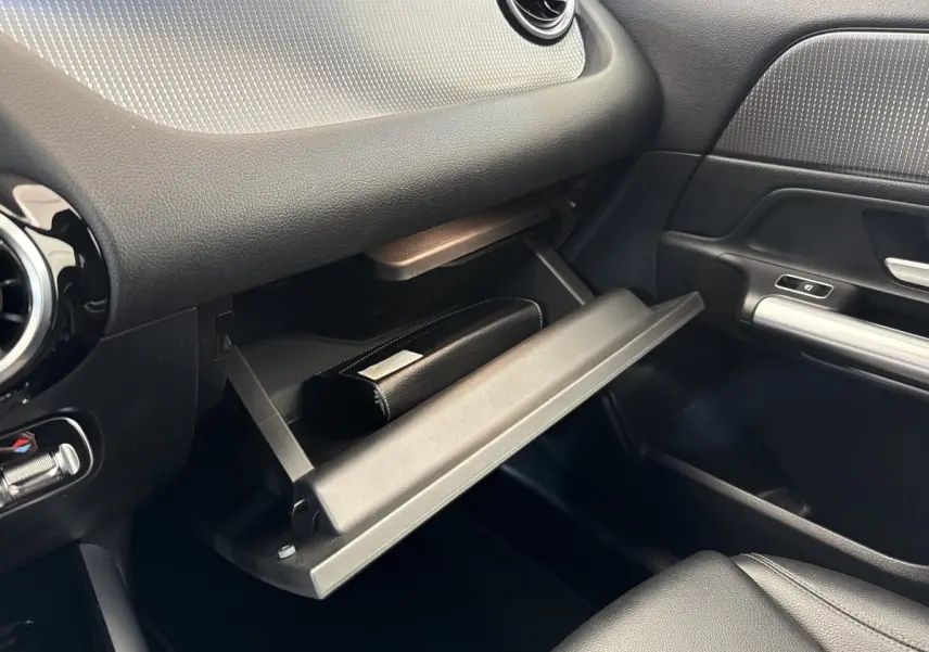 Intérieur du Mercedes GLA 250 e 2021, vue côté passager sur la boîte à gants ouverte avec un étui noir.