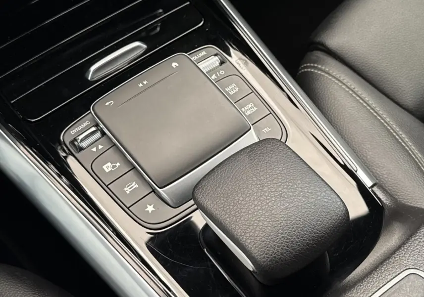 Gros plan sur la console centrale noire avec touchpad et commandes du Mercedes GLA 250 e Business Line 2021.