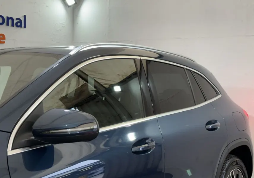 Vue latérale gauche d’un Mercedes GLA 250 e Business Line bleu avec vitres teintées et rétroviseurs chromés.