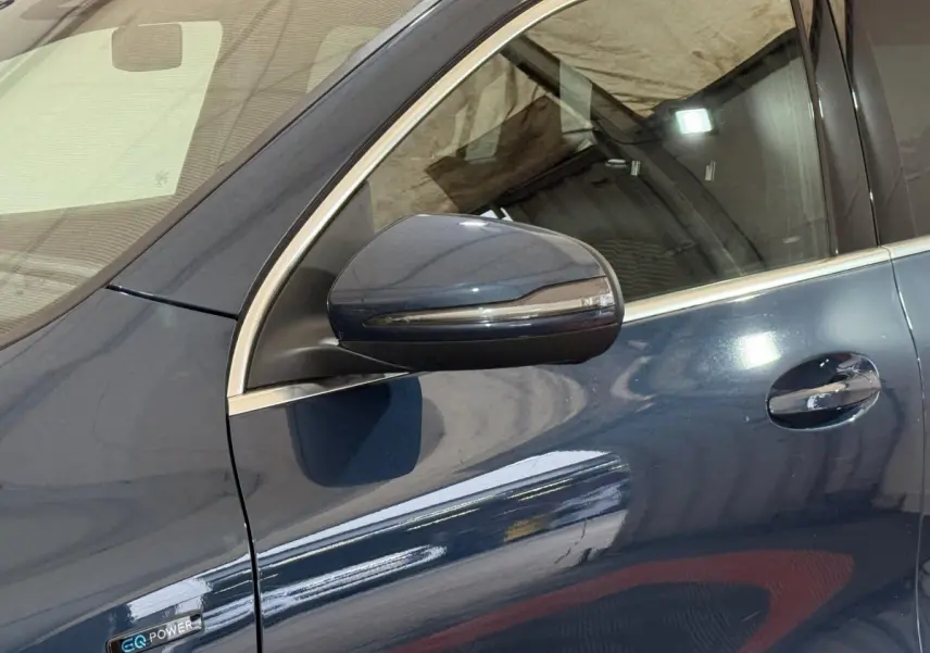 Gros plan sur le rétroviseur et la portière côté gauche d'une Mercedes GLA 250 e Business Line bleu métallisé.