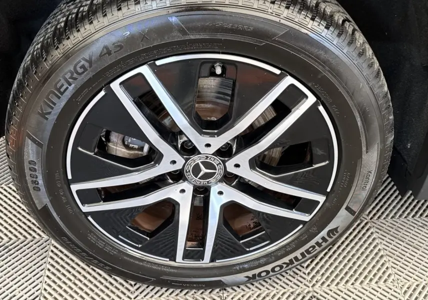 Gros plan sur la jante noire et argentée avec logo Mercedes, montée sur pneu Hankook Kinergy 4S.