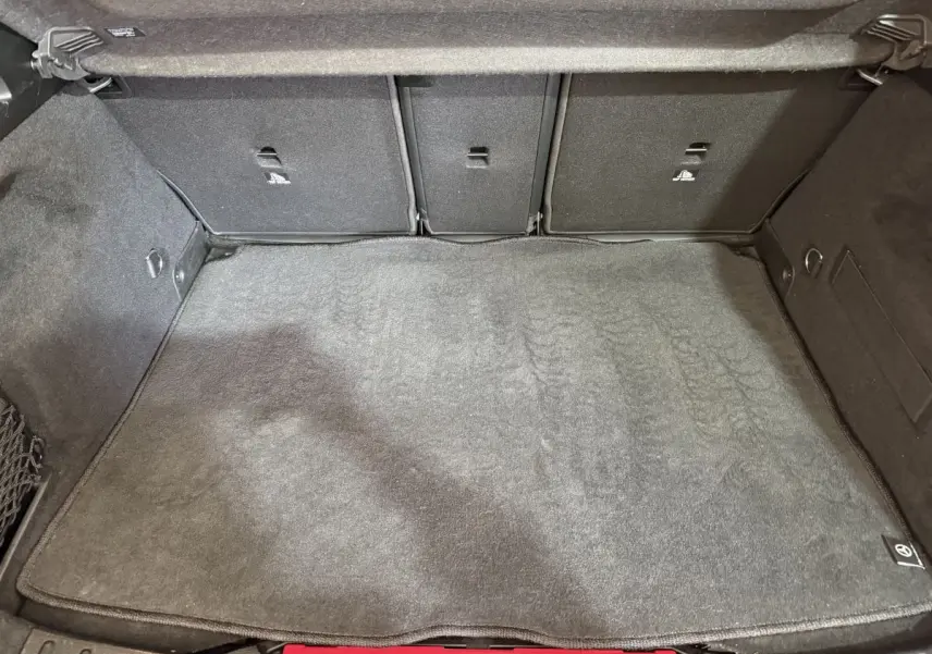 Coffre spacieux de Mercedes GLA 250 e Business Line 2021, vue intérieure, tapis gris et banquette arrière rabattable.