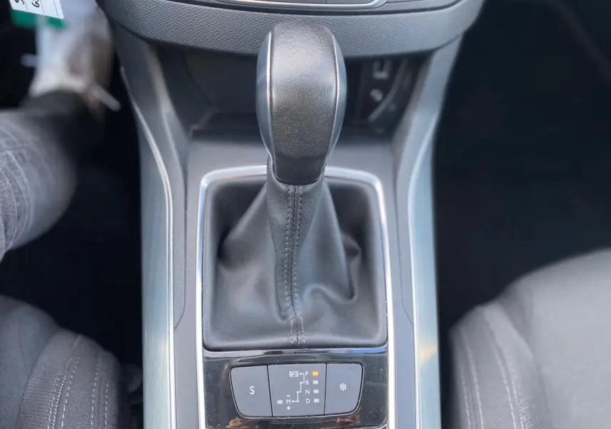 Le levier de vitesse automatique noir de la Peugeot 308 gris aluminium vu de dessus, entouré de la console centrale.