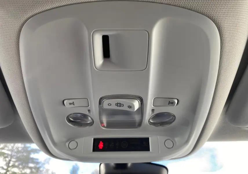 Vue en gros plan du plafonnier intérieur de la Peugeot 308 gris aluminium, montrant les commandes d'éclairage et les voyants.