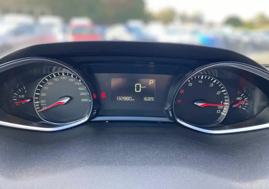 Tableau de bord de Peugeot 308 gris aluminium, affichant compteur et compte-tours avec écran central numérique.