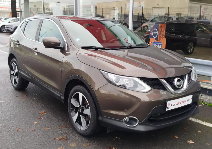 Nissan Qashqai bronze Ultime en 3/4 avant droit, mettant en valeur ses jantes noires et son design compact.