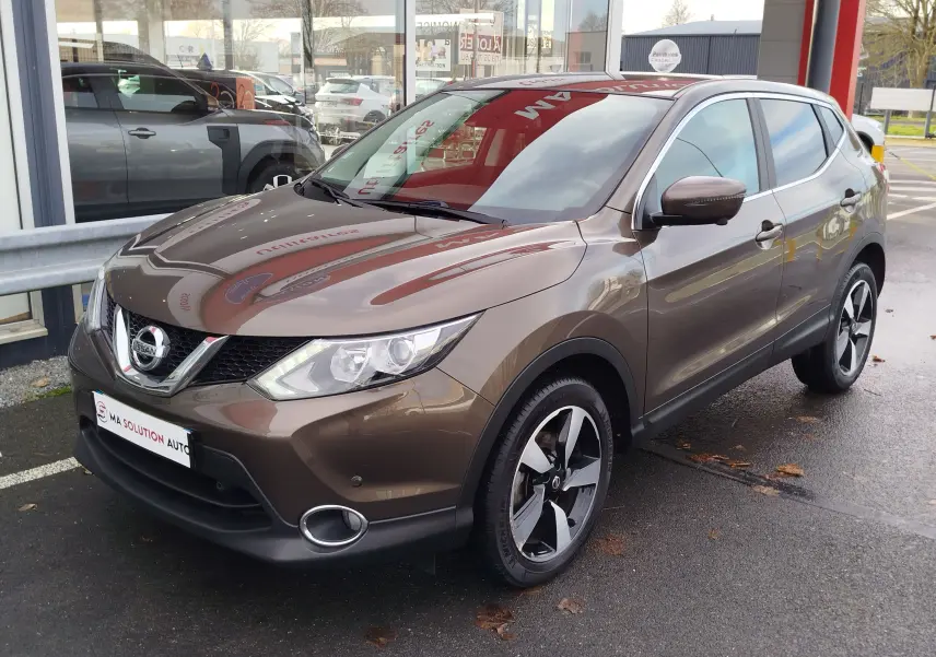 Vue intérieure côté conducteur du Nissan Qashqai 2017, sièges tissu gris foncé et levier de vitesse manuel visible.