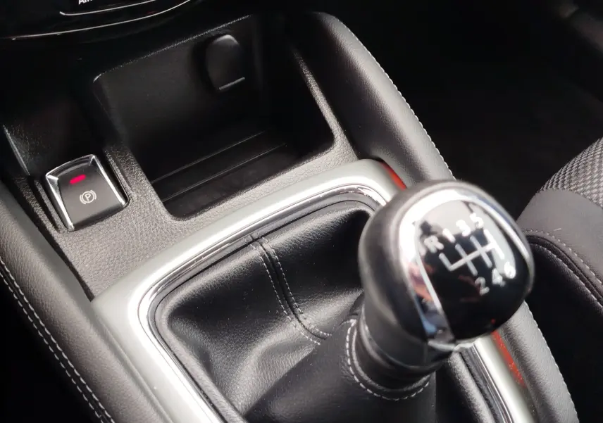 Gros plan sur le volant noir et les commandes intégrées du Nissan Qashqai 2017, tableau de bord partiellement visible.