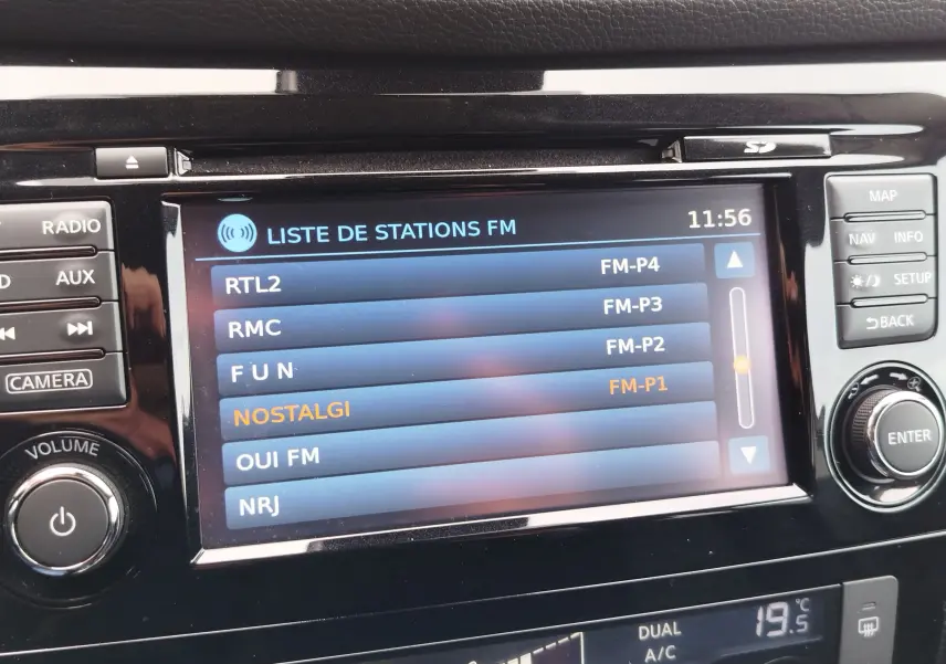 Vue intérieure côté conducteur du Nissan Qashqai 2017, volant cuir, tableau de bord digital et levier de vitesses manuel.