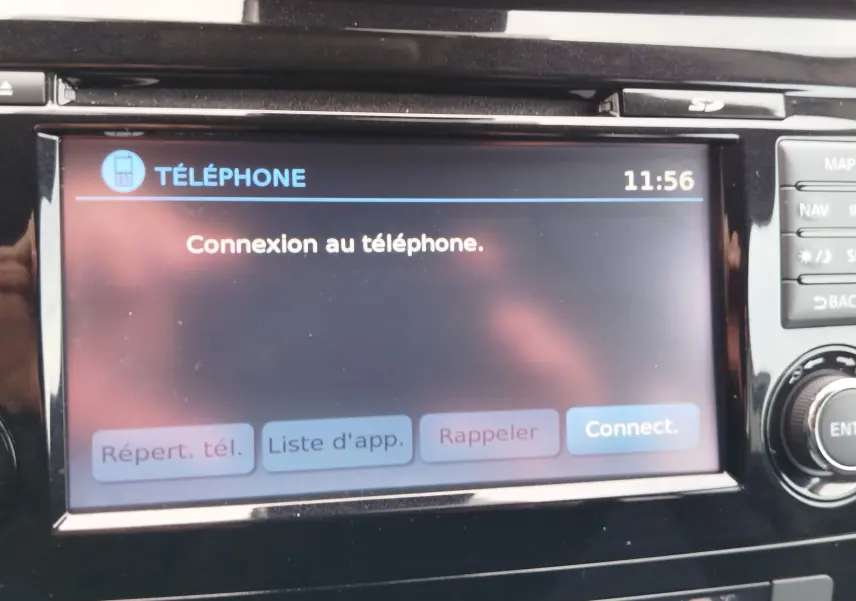 Vue intérieure côté conducteur du Nissan Qashqai 1.2L DIG-T 2017, sièges tissu gris et volant cuir noir.