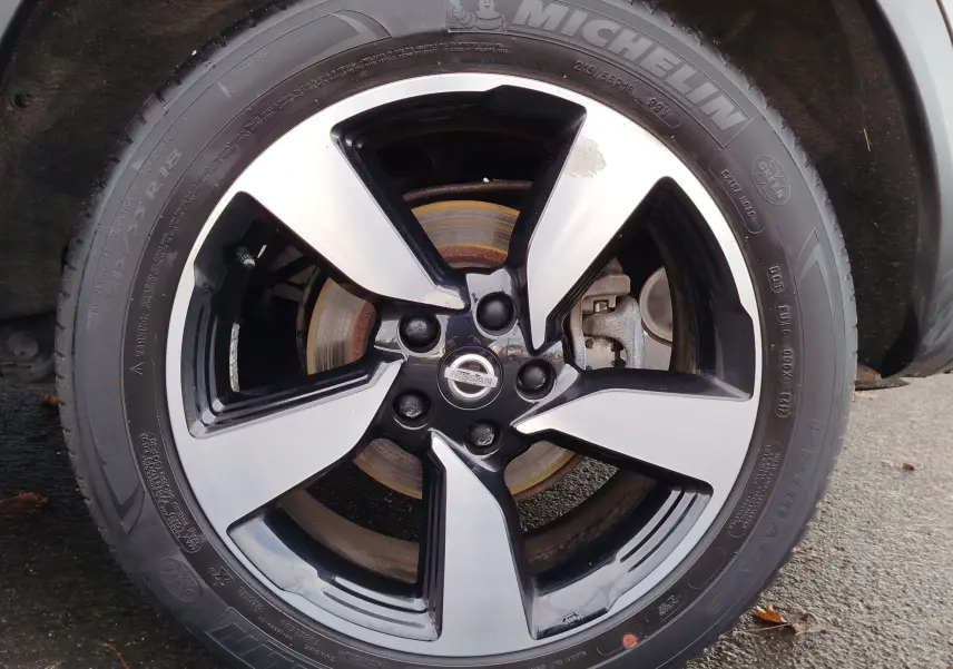 Gros plan sur la jante alliage bicolore noire et argentée d’un Nissan Qashqai Bronze Ultime, pneu Michelin visible.