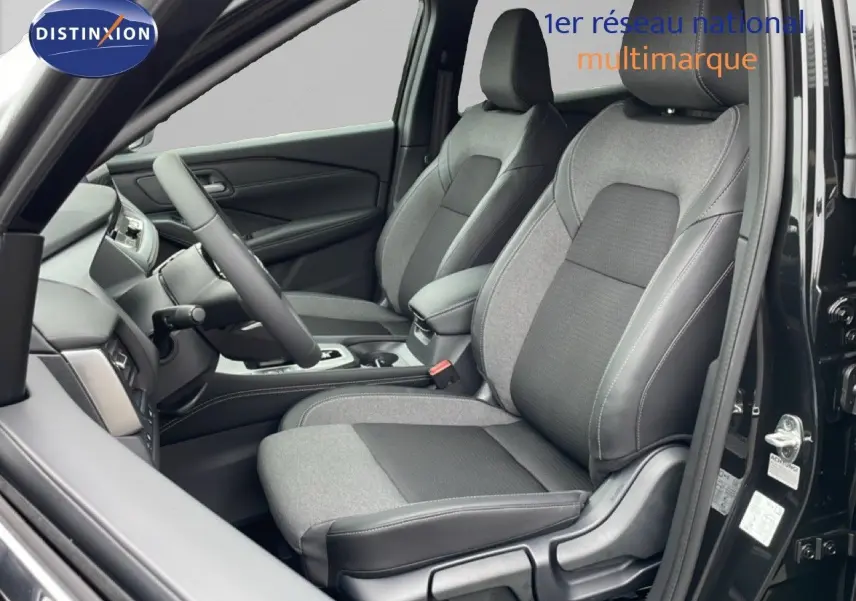 Vue intérieure côté conducteur du Nissan Qashqai 2025 noir perle métal, sièges tissu et cuir gris avec console centrale visible.